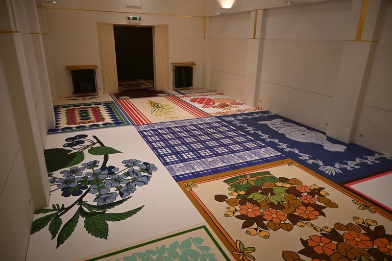 藝術家林明弘在布魯塞爾舉辦個展「茶巾與餐巾」，以日常生活中常見的用品作為創作題材並以拼布畫的樣式在展場呈現。