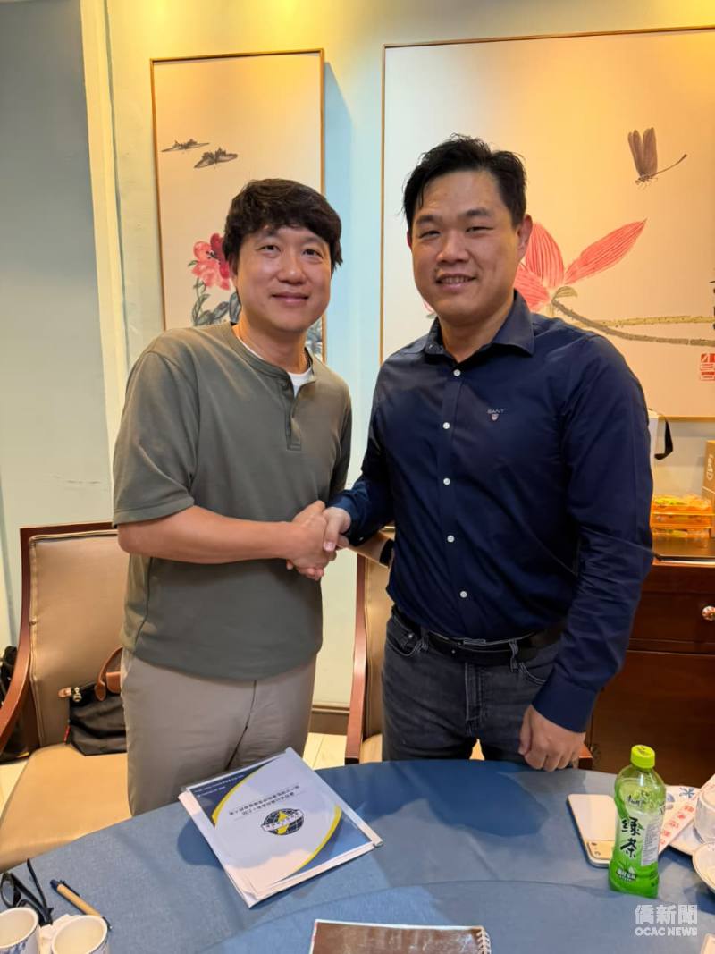 南非豪登省台灣商會新任會長江江根 (右) 與駐南非代表處僑務秘書李永盛 (左) 握手合影。