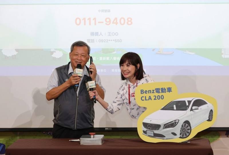 南投縣政府6月19日至10月31日辦理「南投旅遊好康月」消費抽獎活動，首波大獎賓士電動汽車15日由副縣長王瑞德（左）抽出，現場致電幸運兒。（南投縣政府提供）