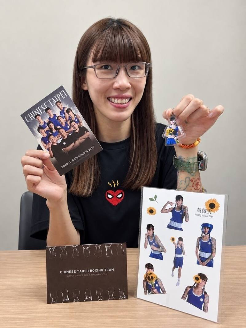 2026名古屋亞運將在19日開幕，台灣拳擊代表隊18日啟程，拳擊協會特地製作應援小物，包括鑰匙圈、貼紙、明信片等，選手黃筱雯（圖）開心展示自己的應援小物。（中華民國拳擊協會提供）