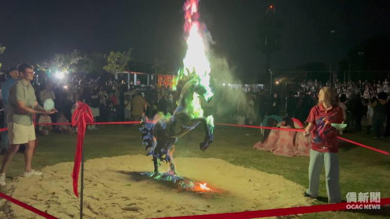 Creative and Visual Arts Teacher Gabriella Sale lights the life-size “Fire Horse” art installation, using coloured powder to transform the flames while bringing together the auspicious symbolism of immediate success, Chinese zodiac culture, visual art and