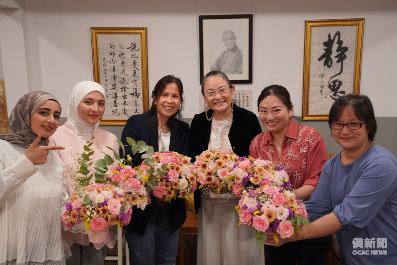 「花好月圓」中秋花藝文化交流活動中，與會來賓及學員手捧親手完成的花藝作品合影，在花香與笑容中留下溫馨的交流時刻。