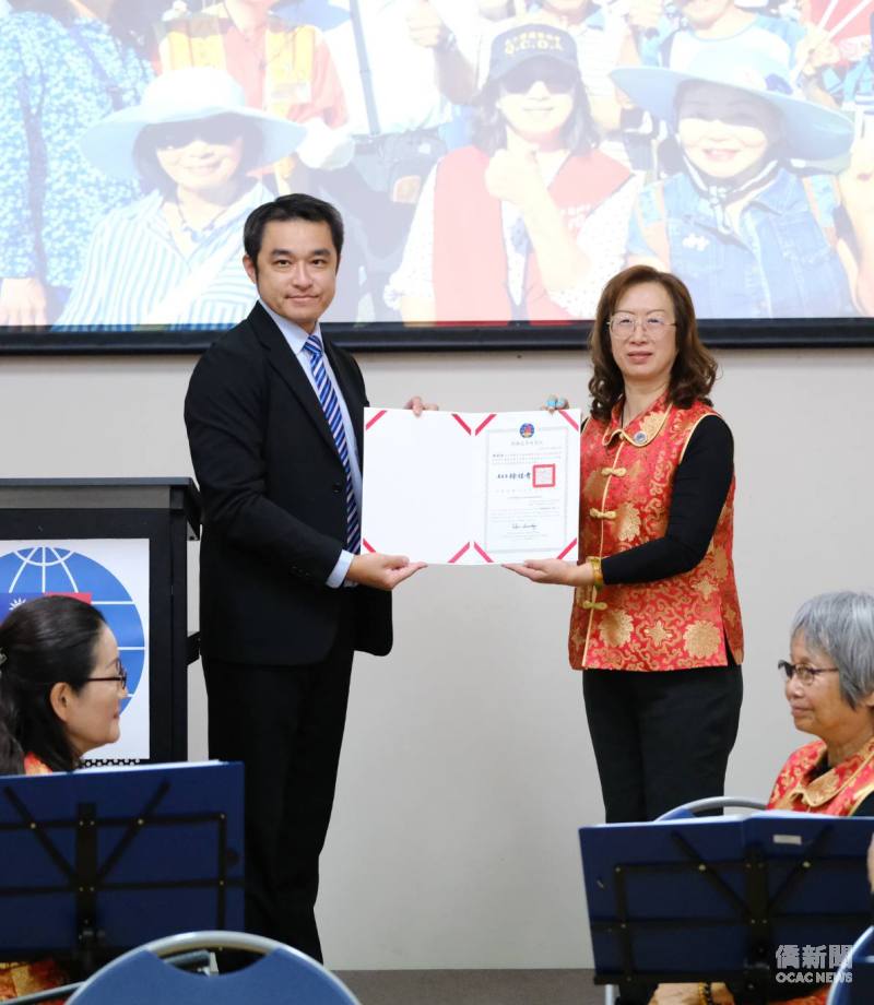 昆士蘭臺灣中心主任許俊湧代表僑務委員會委員長徐佳青頒發會長連任賀狀予蘇毓敏。(主辦方提供)