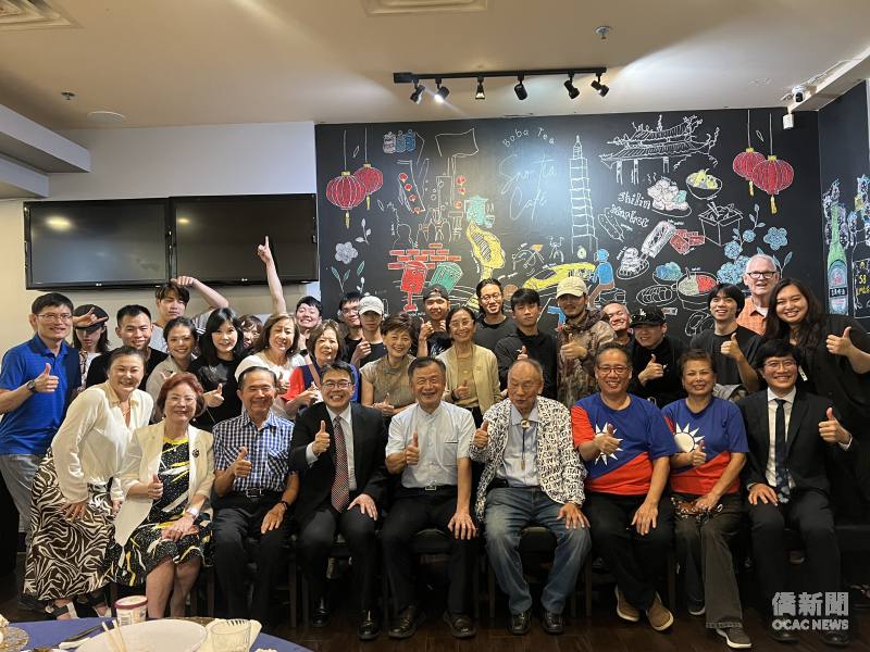 周啟宇(前排左4)偕杜戎珄(前排右1)於演出前一日舉辦歡迎餐會，迎接邱太三(前排右5)及國慶文化訪問團一行。主辦僑團佛州華商總會會長鄧志安(前排右3)，以及僑務諮詢委員楊喬生(前排右4)、王成章(前排左3)等人共同參與