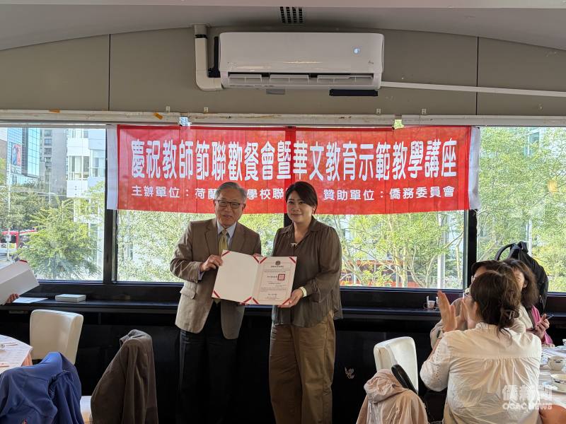 駐荷蘭代表處大使田中光（左）代表僑務委員會頒發僑民學校教師任教屆滿5年獎狀予老師洪婉瑜（右）。