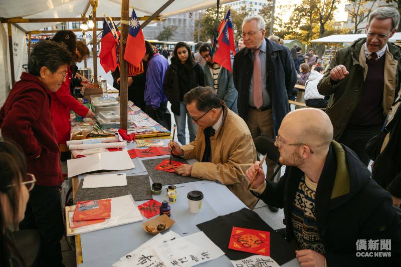 駐德國代表處大使谷瑞生（右二坐者）於臺灣文化日市集揮毫題字送給現場的貴賓。