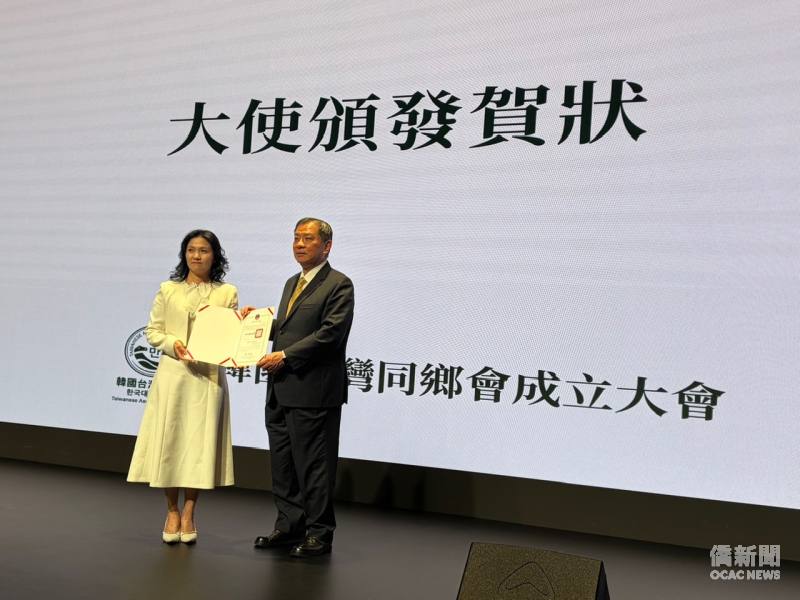丘高偉(右)代表僑委會頒發賀狀予韓國台灣同鄉會會長劉溢利(左)。