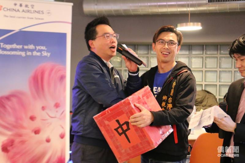 華航荷蘭分公司總經理龔元昭（左）與荷蘭臺灣鄉親聯誼會會長林昭彥（右）於摸彩活動中互動；華航提供臺荷往返機票作為獎項，為現場增添驚喜與歡樂。