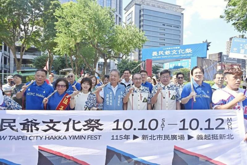 新北市長侯友宜（前右4）與新北市議會議長蔣根煌（前左4）、副議長陳鴻源（前右3）等人11日出席客家義民爺文化祭活動，參與挑擔奉飯創意踩街，共同挑起飯擔。（市府提供）