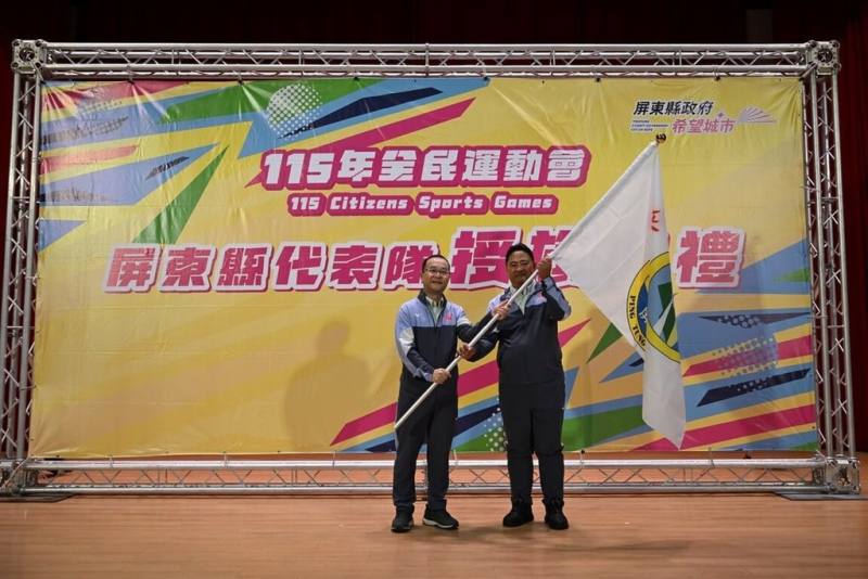 115年全民運動會將開幕，屏東縣政府副秘書長江國豐（左）12日授旗代表隊，盼勇奪榮耀。（屏東縣政府提供）