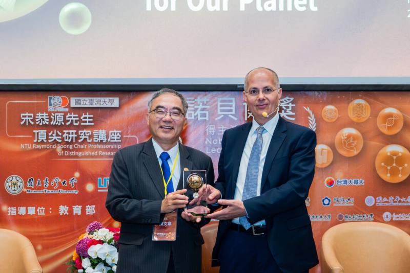 2025年諾貝爾化學獎得主奧馬爾．亞基（Omar M. Yaghi，另譯：歐瑪．亞基）（右）受邀到台灣大學演講，他表示，AI時代科研的關鍵是從龐大的可能性中，辨識出真正值得投入的方向，走向「選擇科學」的思維。左為台大校長陳文章。（台大提供）