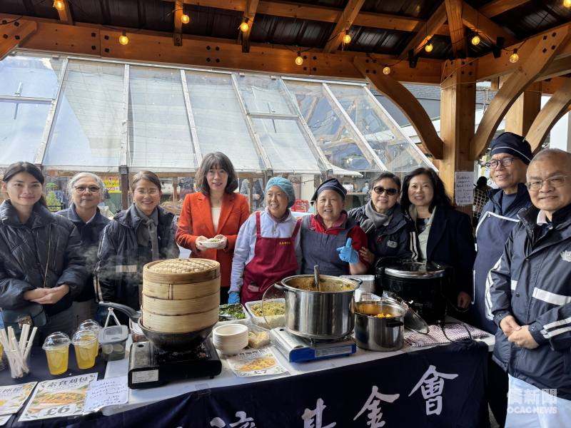 江雅綺參訪慈濟英國基金會攤位，與現場志工合影交流，體驗臺灣特色美食，感受慈濟人文與公益精神。