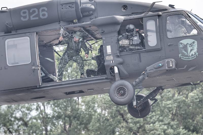 陸軍第十軍團指揮部22日在台中成功嶺營區舉行「營區開放全兵力預校暨媒體邀訪活動」，UH-60M黑鷹直升機參與快速繩降操演，機艙門邊官兵（左）觀察機外狀況，機槍手（中）持續警戒。
